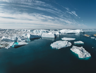 Iceberg and ice from glacier in arctic nature landscape in Ilulissat,Greenland. Aerial drone photo of icebergs in Ilulissat icefjord. Affected by climate change and global warming. - obrazy, fototapety, plakaty