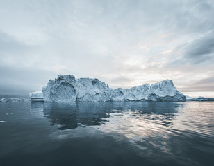 Bright sunny day in Antarctica. Full calm and reflection of icebergs in deep clear water. Travel by...