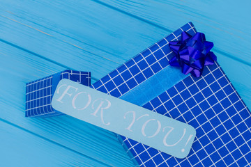 Blue gift box and for you note. Top view. Blue wooden background.