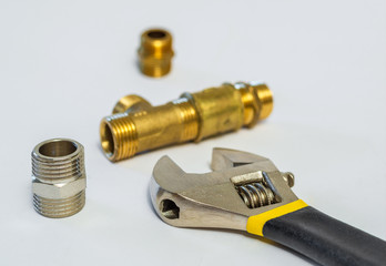 Set of brass fittings is often used for water and gas installations on background of tools
