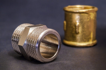 Set of brass fittings is often used for water and gas installations on dark background