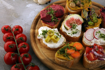 Assorted bruschetta with various toppings. Appetizing bruschetta or brie crostini. Variety of small sandwiches. Mix bruschetta on table