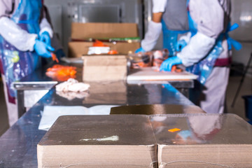 Fish production. Worker lays out pieces of fish on the packaging for further sealing