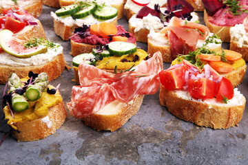 Assorted bruschetta with various toppings. Appetizing bruschetta or brie crostini. Variety of small sandwiches. Mix bruschetta on table