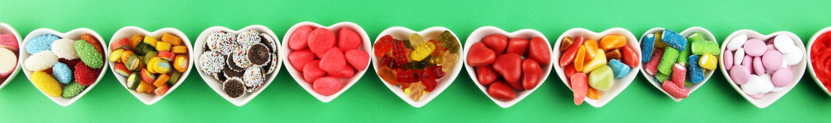 candies with jelly and sugar. colorful array of different childs sweets and treats on green...