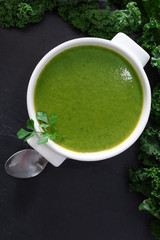 broth or cream of natural vegetables on the plate on black stone background