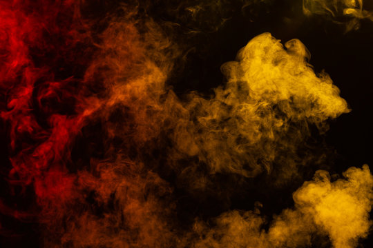Billowing red and yellow smoke on black background