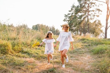 Fototapeta premium Mother and daughter having fun in the park. Happiness and harmony in family life. Beauty nature scene with family outdoor lifestyle. Mother's Day
