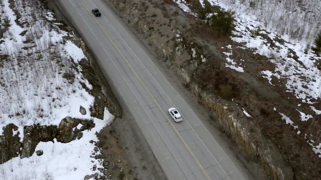 Aeriel bird's eye view of cars driving on a cold northern road