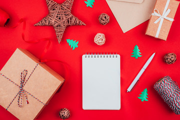 Blank notebook, pen, craft gift boxes, envelope, red bow, clew of tricolor rope, ribbon and...
