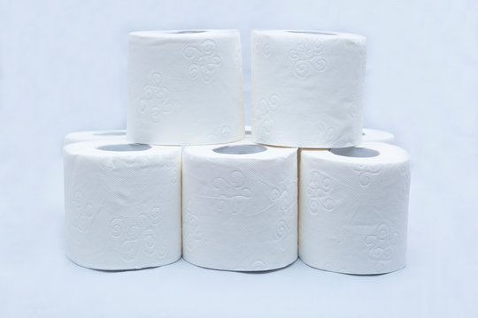 White toilet paper on white background. A few rolls.