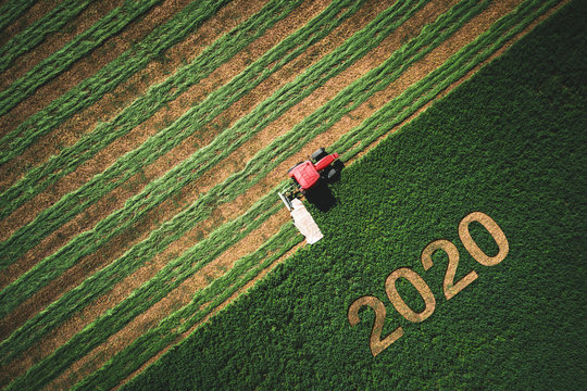 2020 Happy Ney Wear concept and red tractor mowing green field