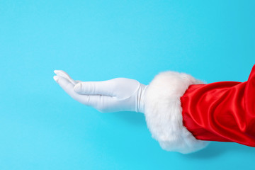 Santa Claus glove hand blue background one red suit copy space