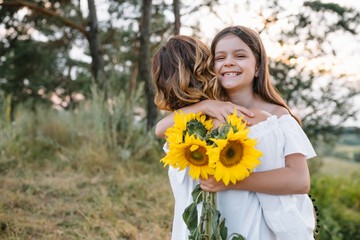 Fototapeta premium Stylish mother and handsome daughter having fun on the nature. Happy family concept. Beauty nature scene with family outdoor lifestyle. family resting together. Happiness in family life. Mothers day
