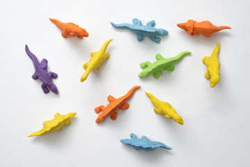 colorful children's toys dinosaurs made of thermoplastic elastomer on a white background - obrazy, fototapety, plakaty