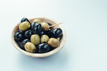 Olives in a bowl with copyspace on white background