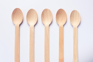 Wooden spoons arranged in an order on white background