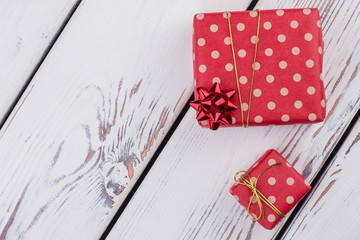 Obraz premium Christmas gift boxes and copy space. Gift boxes with ribbons on white wooden background with text space. Holiday celebration concept.