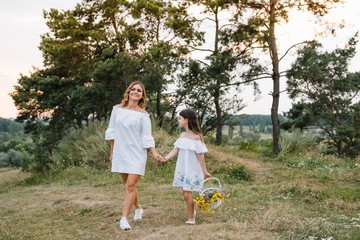 Stylish mother and handsome daughter having fun on the nature. Happy family concept. Beauty nature scene with family outdoor lifestyle. family resting together. Happiness in family life. Mothers day