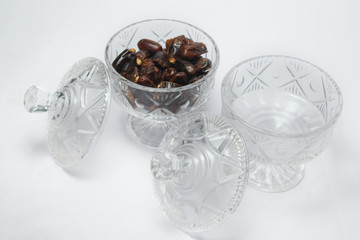 empty glass jar and jar containing dates on white background