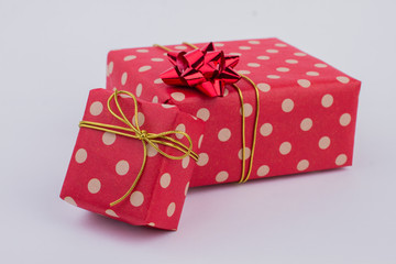 Red dotted gift boxes on gray background. Christmas holiday gift boxes with bow isolated. Holiday greeting background.