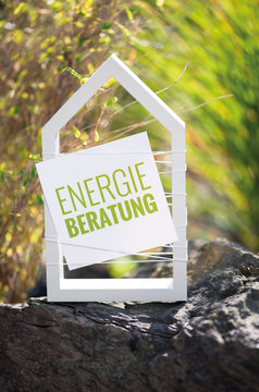 Wei&szlig;es Haus vor nat&uuml;rlichen Hintergrund mit Schild Energieberatung