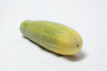 withered cucumber with green and yellow color on white background