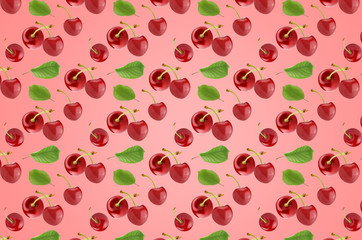 Pattern of cherry fruits with leaves on the pink surface