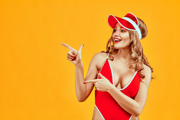 Beautiful sexy woman dressed in red bikini advertises product against yellow background.Advertisement concept.