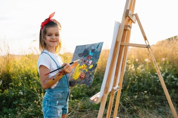 Little Girl Is Painting Picture Outdoors