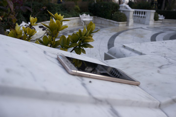 Macro closeup of smartphone, forgotten lying on marble at park