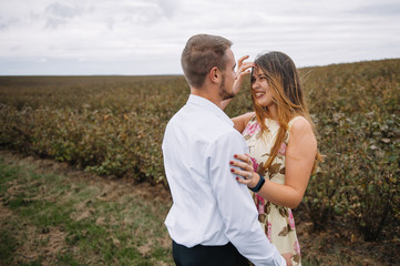 A girl and a guy are walking in the nature. Portrait of a couple, a love story.Happy smiling, loveing couple together outstretched at beautiful nature. Lovestory