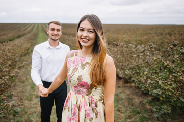 A girl and a guy are walking in the nature. Portrait of a couple, a love story.Happy smiling, loveing couple together outstretched at beautiful nature. Lovestory