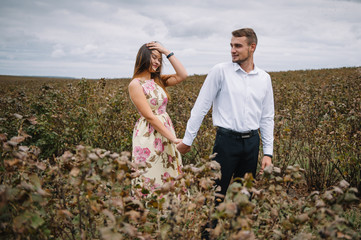 A girl and a guy are walking in the nature. Portrait of a couple, a love story.Happy smiling, loveing couple together outstretched at beautiful nature. Lovestory