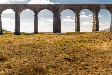 Arches of a graceful railway viaduct, telephoto.
