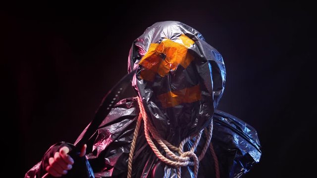 black plastic monster with a machete in his hand on a black background
