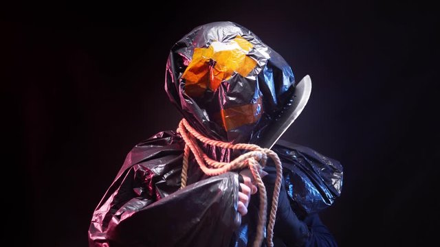 black plastic monster with a machete in his hand on a black background