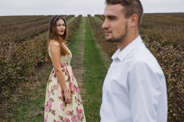 A girl and a guy are walking in the nature. Portrait of a couple, a love story.Happy smiling, loveing couple together outstretched at beautiful nature. Lovestory