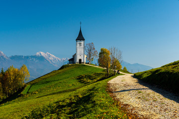 Fototapeta premium Closeup of Jamnik Church in autumn sunlight, Slovenian Alps