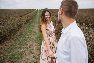 A girl and a guy are walking in the nature. Portrait of a couple, a love story.Happy smiling, loveing couple together outstretched at beautiful nature. Lovestory