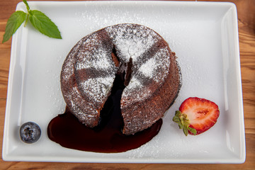 Chocolate souffle with melting centre. Chocolate fondant lava cake with strawberries.