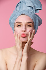 Beauty treatment - woman applying clay face mask