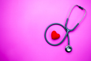 Stethoscope on a pink background with space for text.