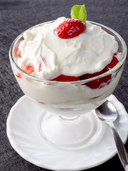 Strawberries with whipped cream in a glass bowl