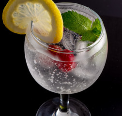 A glass of alcoholic cocktail with cherries, lime and ice - 306792816