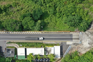 Aerial cenital photo of a car at the entrance of a tunnel