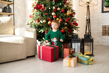 Cute little boy with happy New Year gifts