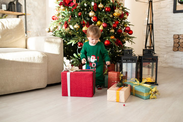 Toddler with Christmas present, Christmas tree on the background