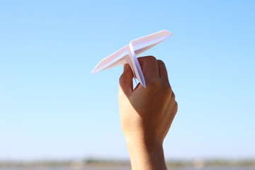 Fototapeta na wymiar Hand holding paper airplane in the sky.