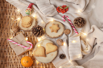 box with a gift in kraft paper, tied with twine, cones, gingerbread cookies, garland lights, caramel Christmas sticks, christmas and new year concept, copy space